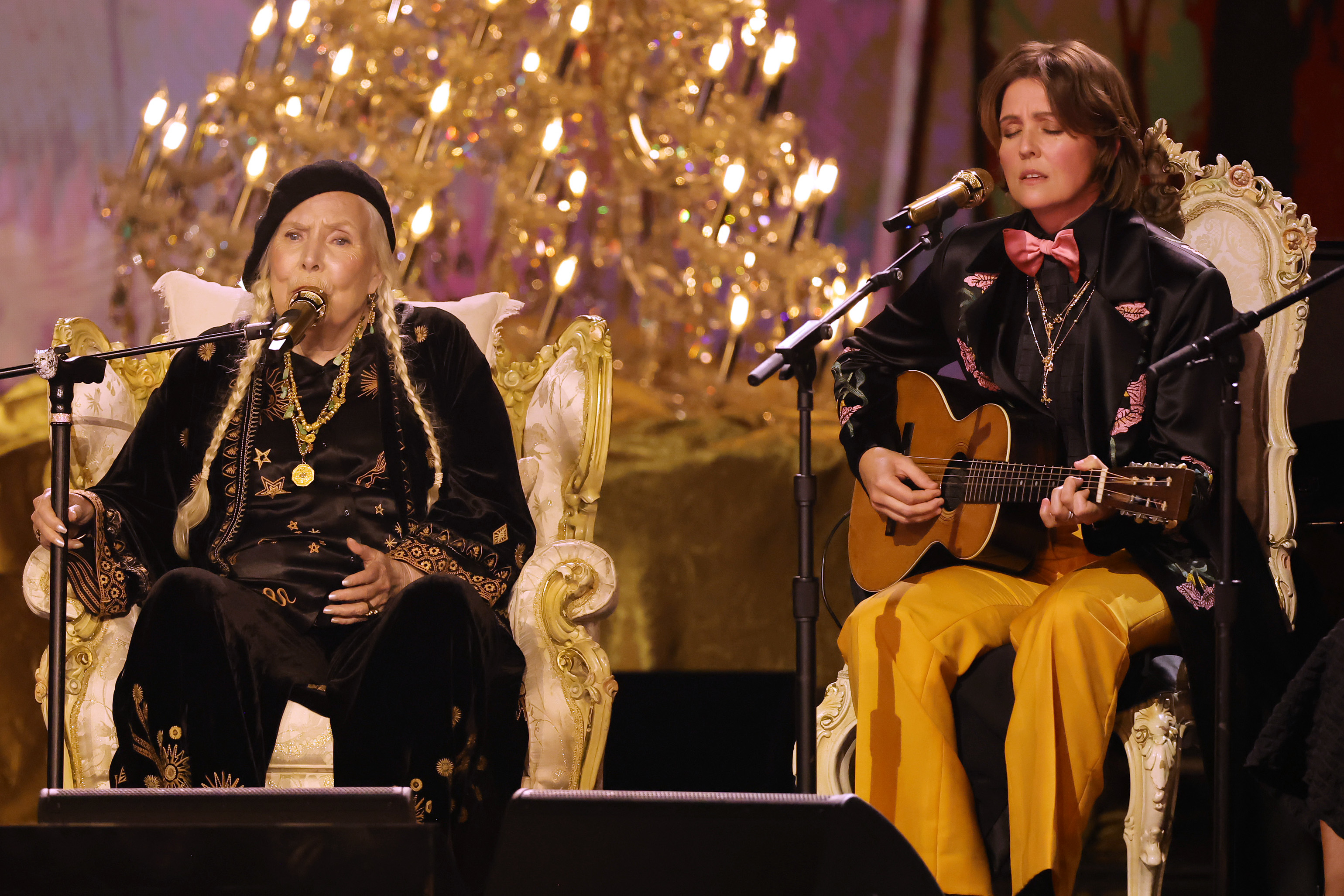 Joni Mitchell and Brandi Carlile sitting onstage at the Grammys as they perform