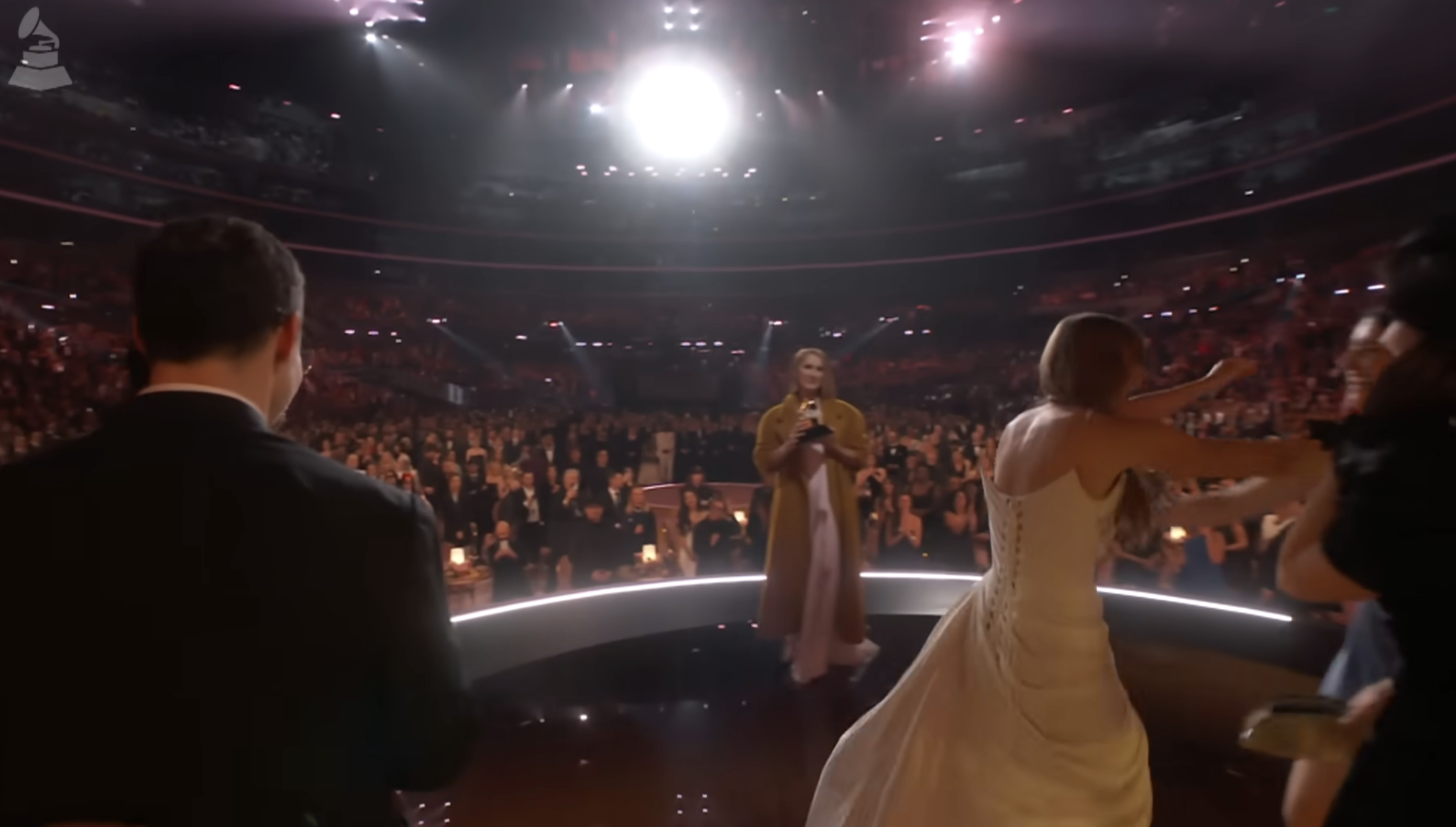 Close-up of Taylor onstage at the Grammys with Céline looking at her