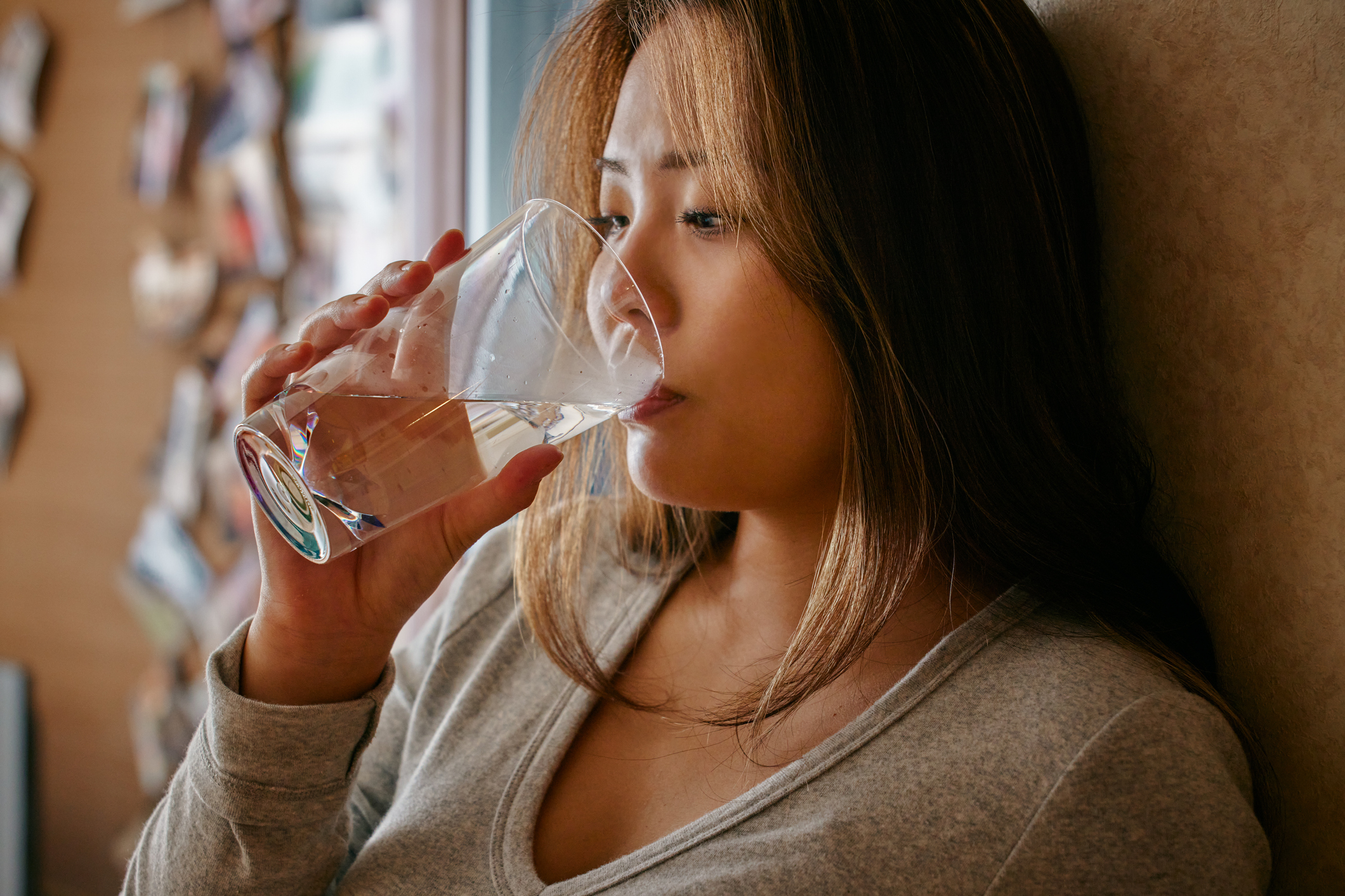 a young woman drinking a glass of water
