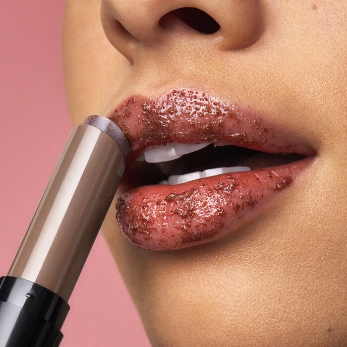 model using a brown E.l.f. Cosmetics lip exfoliator