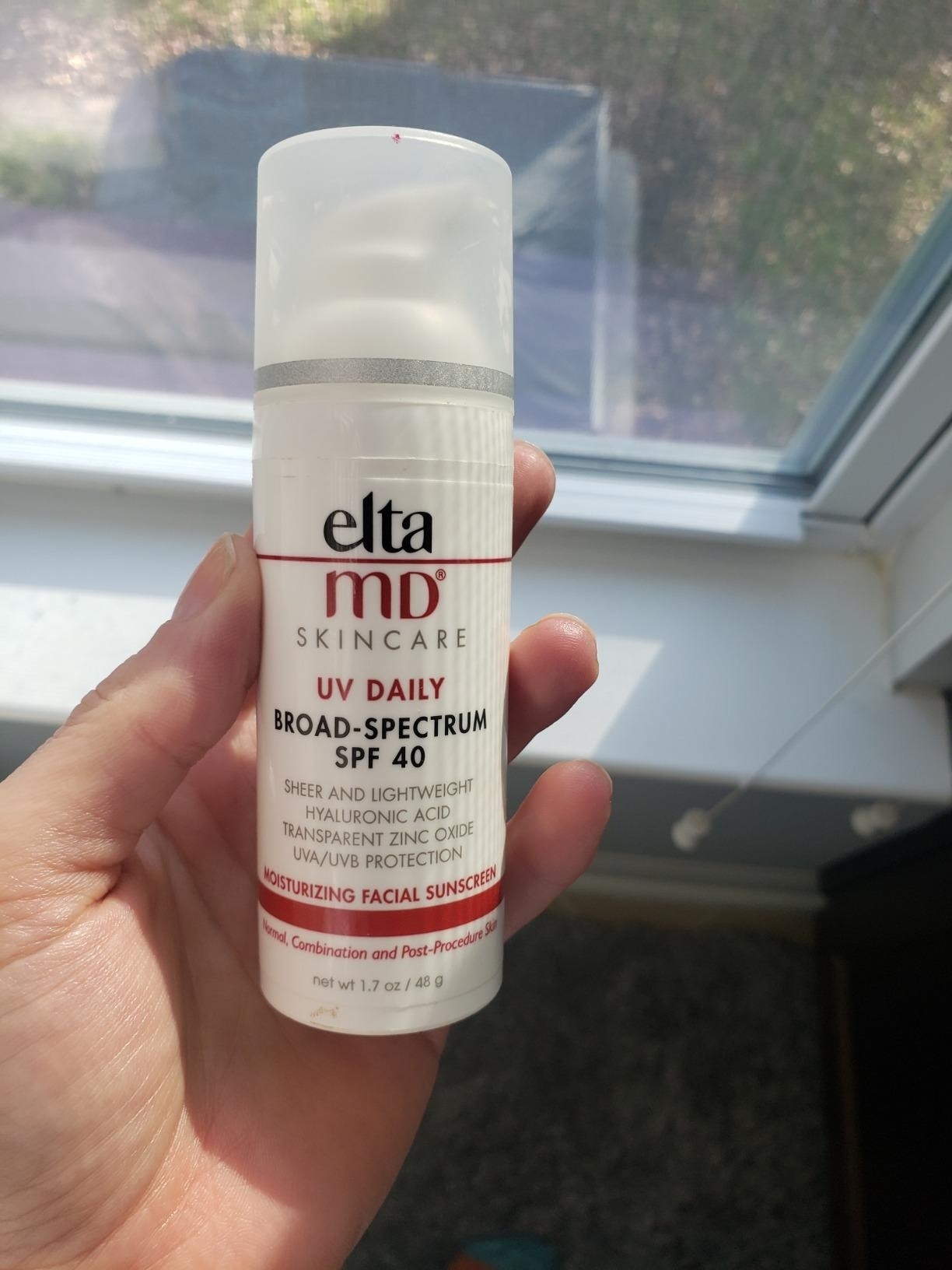 reviewer holding container of Elta MD SPF 40 sunscreen