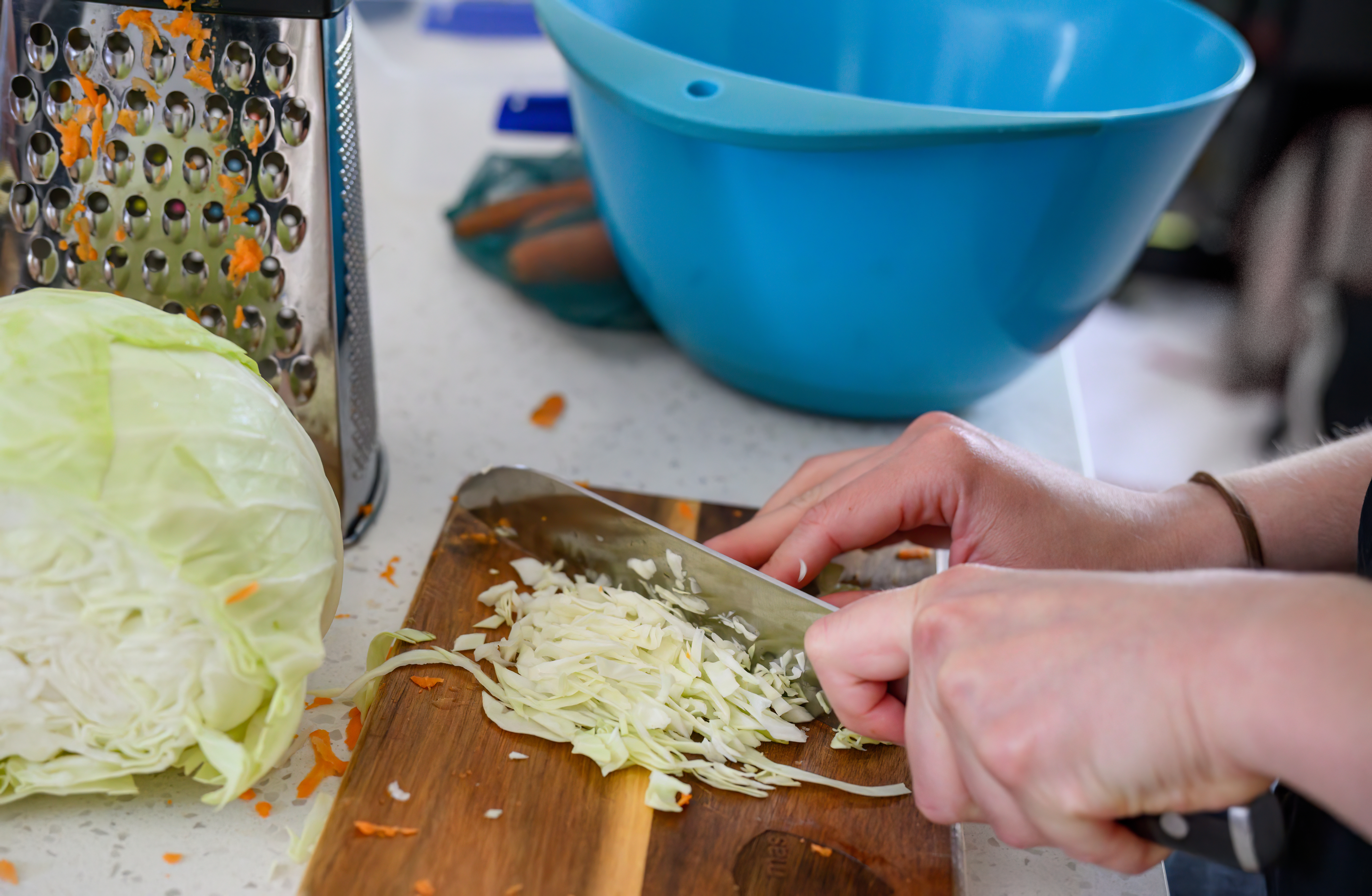 woman cutting a head of cabbage