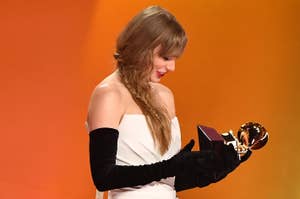 Taylor Swift admiring a Grammy Award