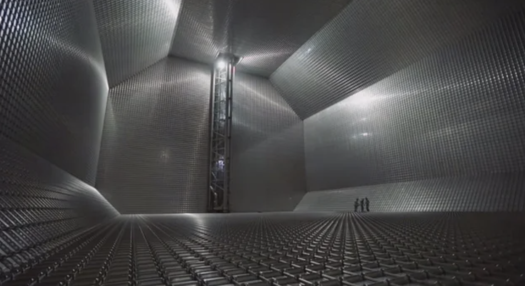 Several people inside an otherwise empty, cavernous interior