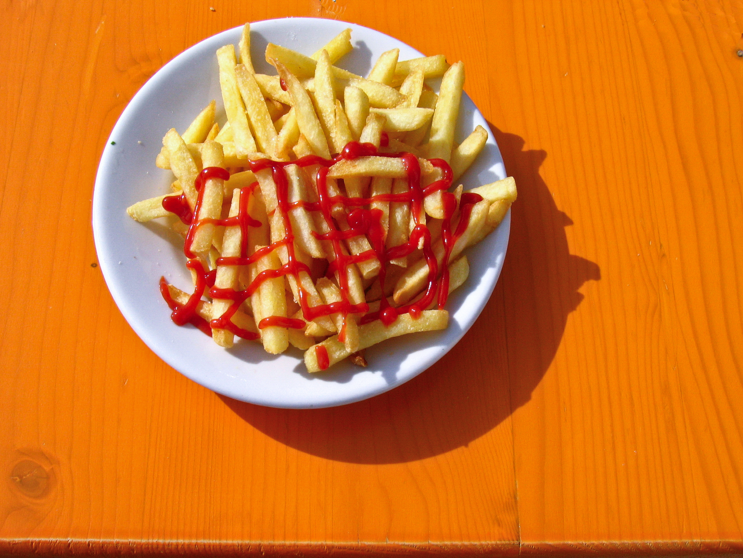 A plate of french fries with ketchup