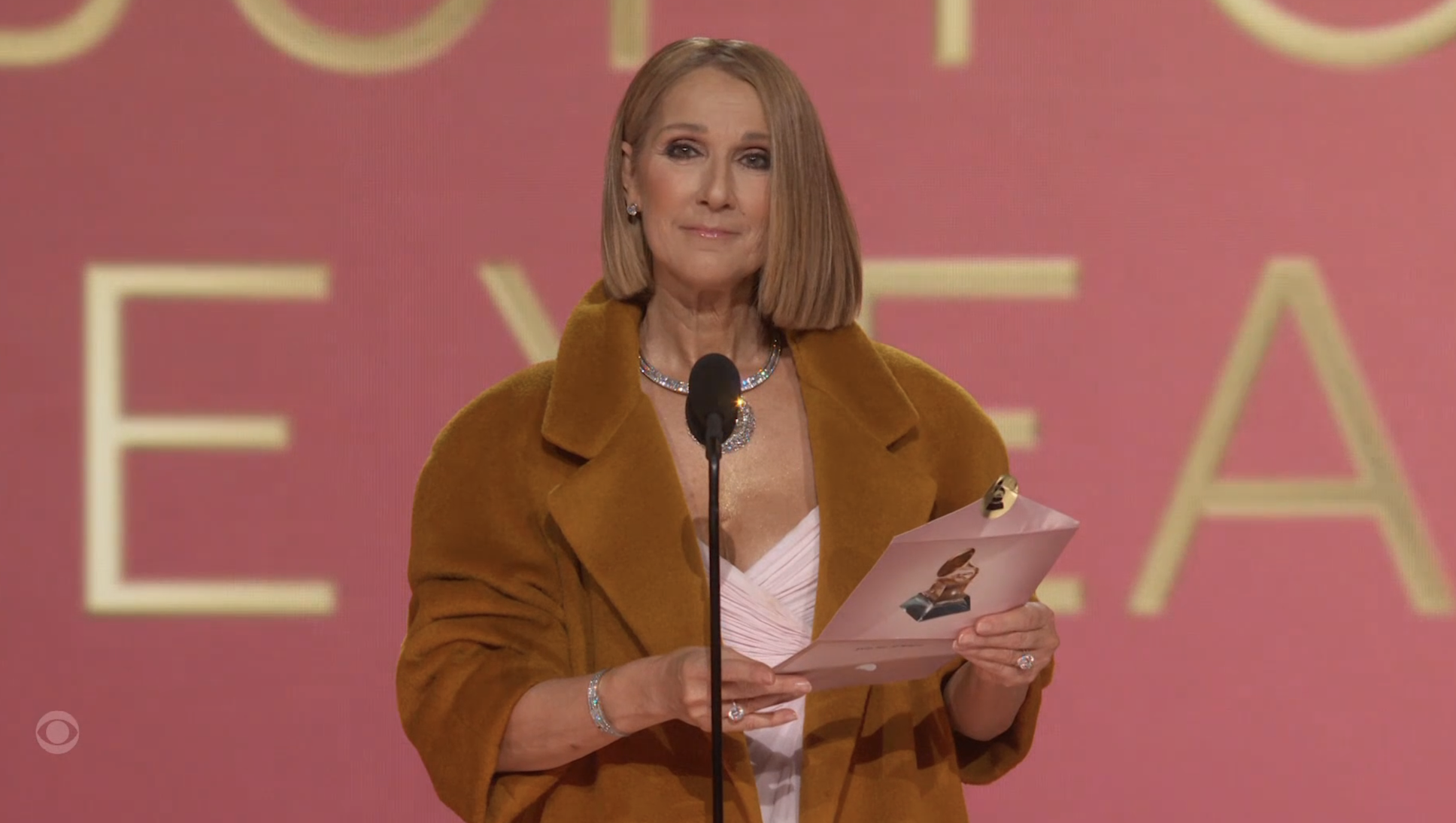 Close-up of Céline onstage at the Grammys opening the envelope to present the award