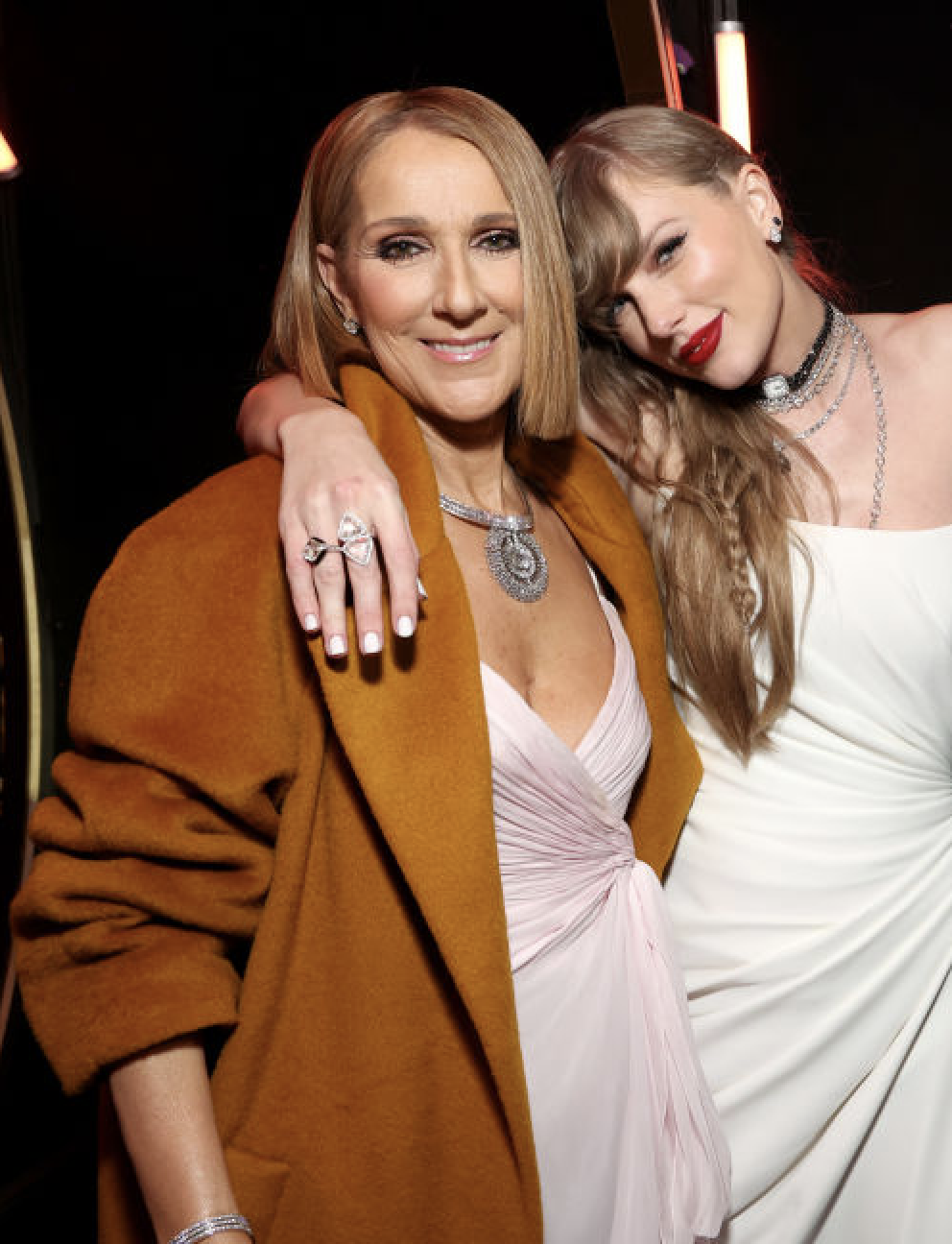 Close-up of Taylor with her arm around Céline&#x27;s shoulders
