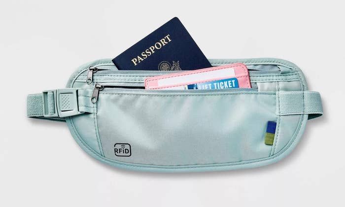 The pouch in a light gray-blue color,  with a zip compartment and a zip pocket and adjustable strap