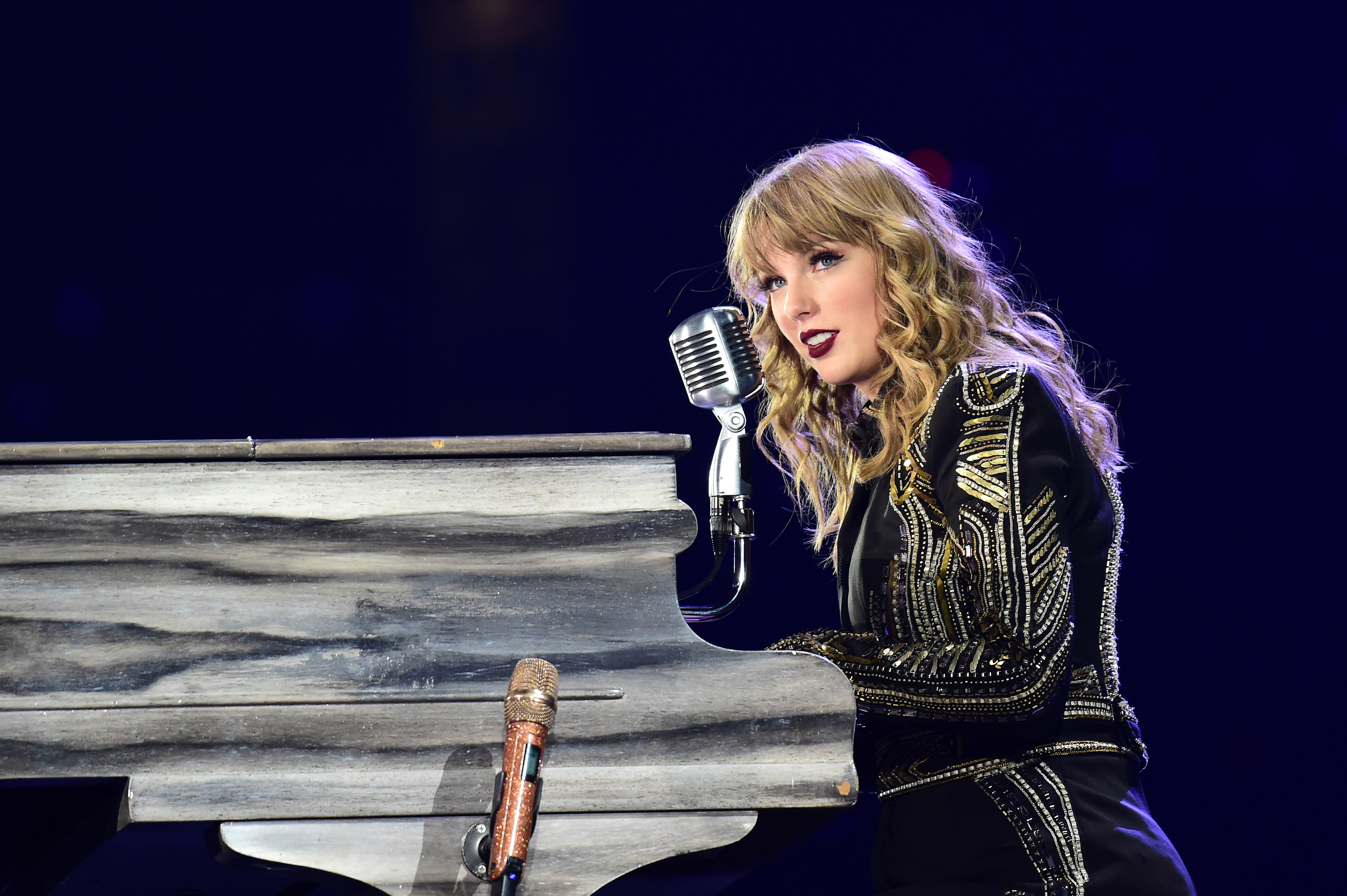 Closeup of Taylor Swift onstage sitting at a piano