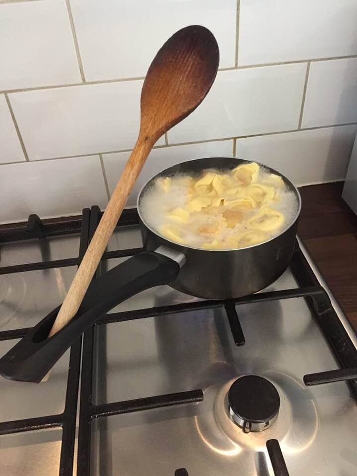A wooden spoon placed in the hole of a pot handle