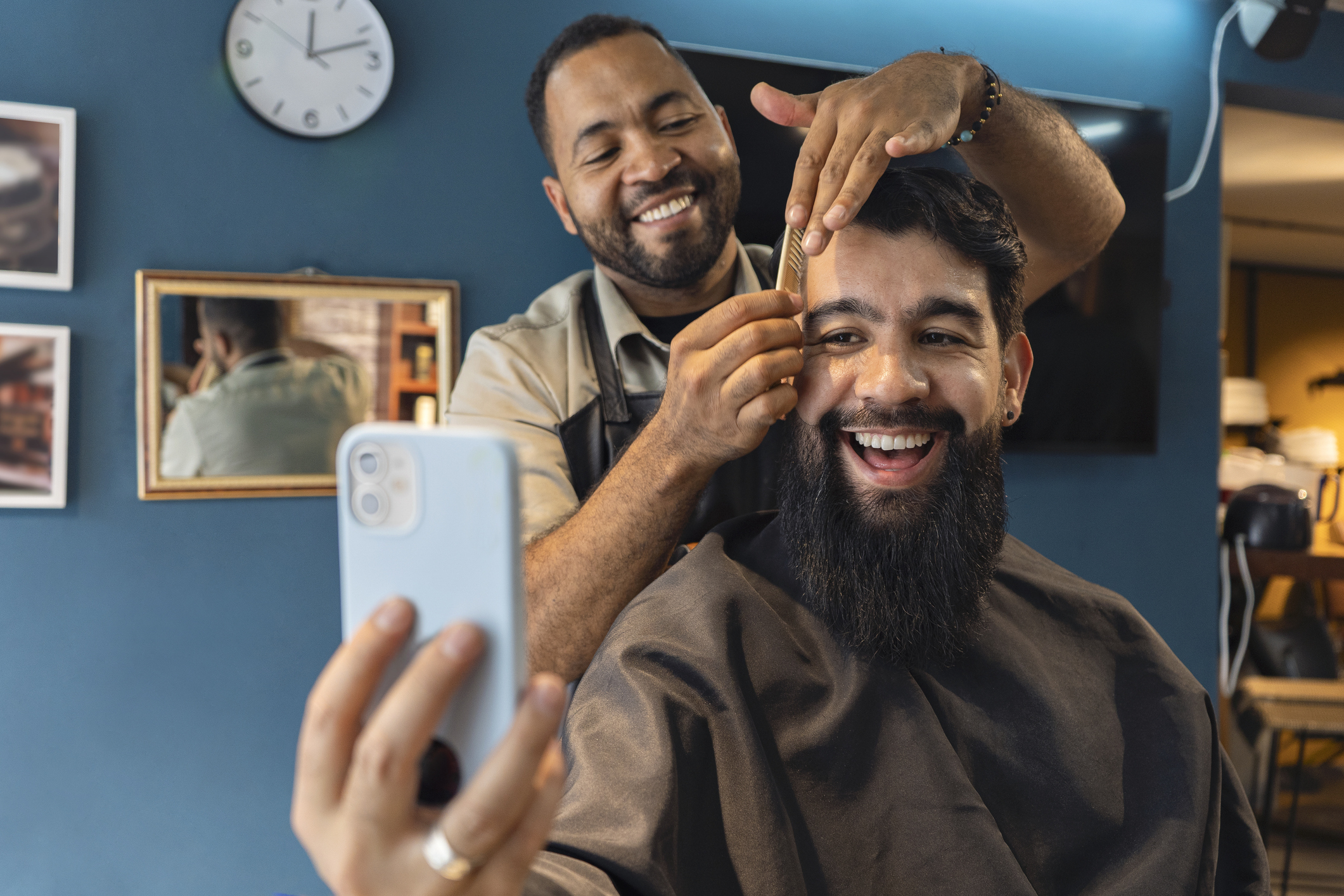 person taking a selfie while getting their hair cut