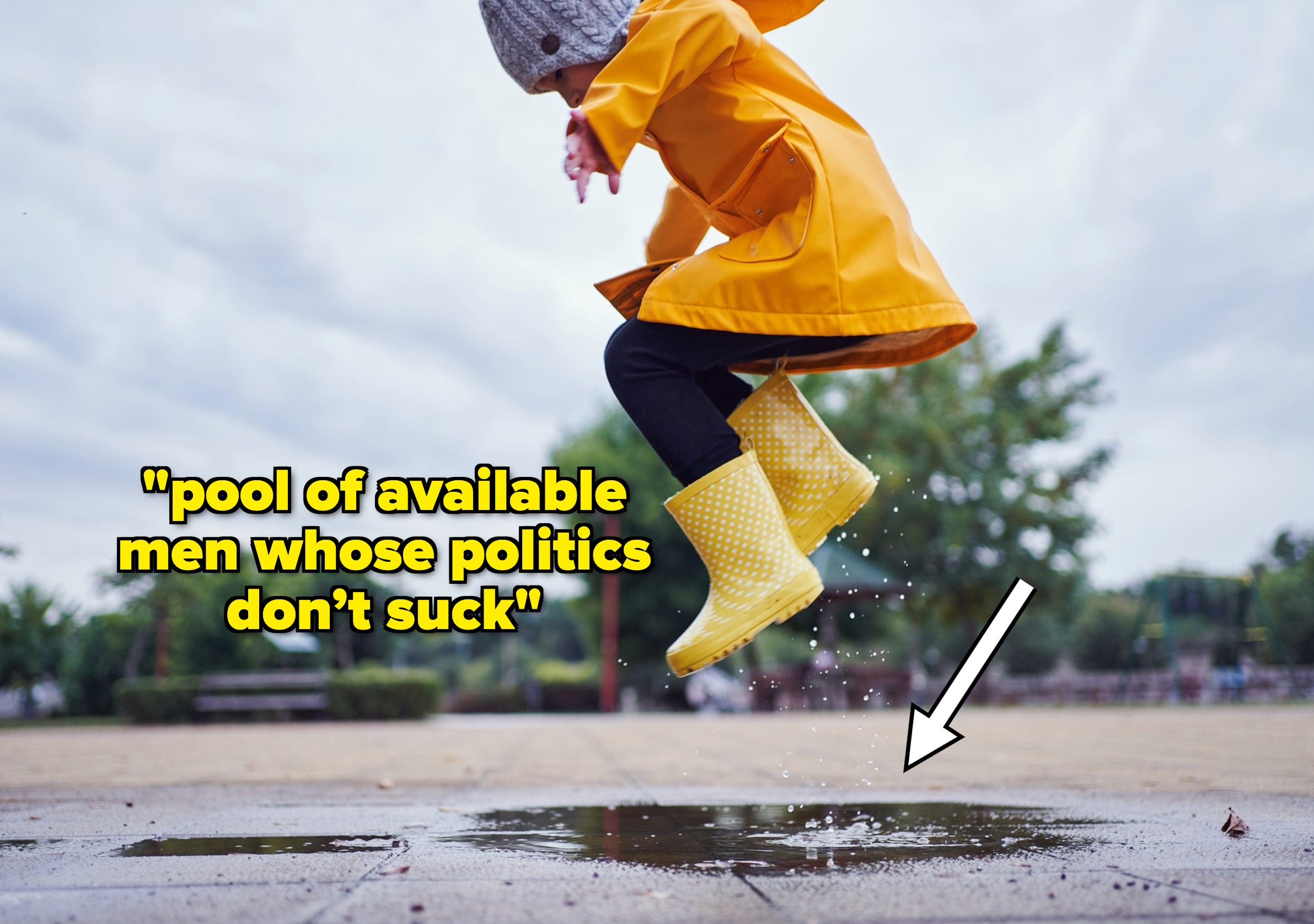Cute and playful female child jumping in a puddle of water on the street wearing yellow rubber boots and a raincoat