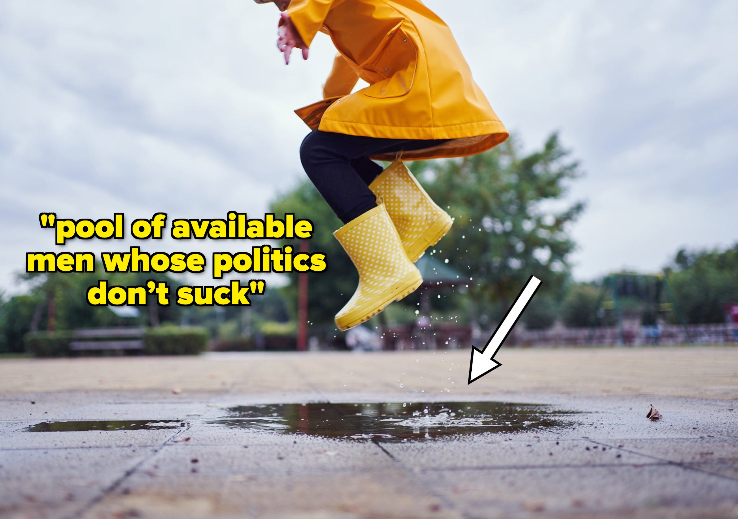 Cute and playful female child jumping in a puddle of water on the street wearing yellow rubber boots and a raincoat