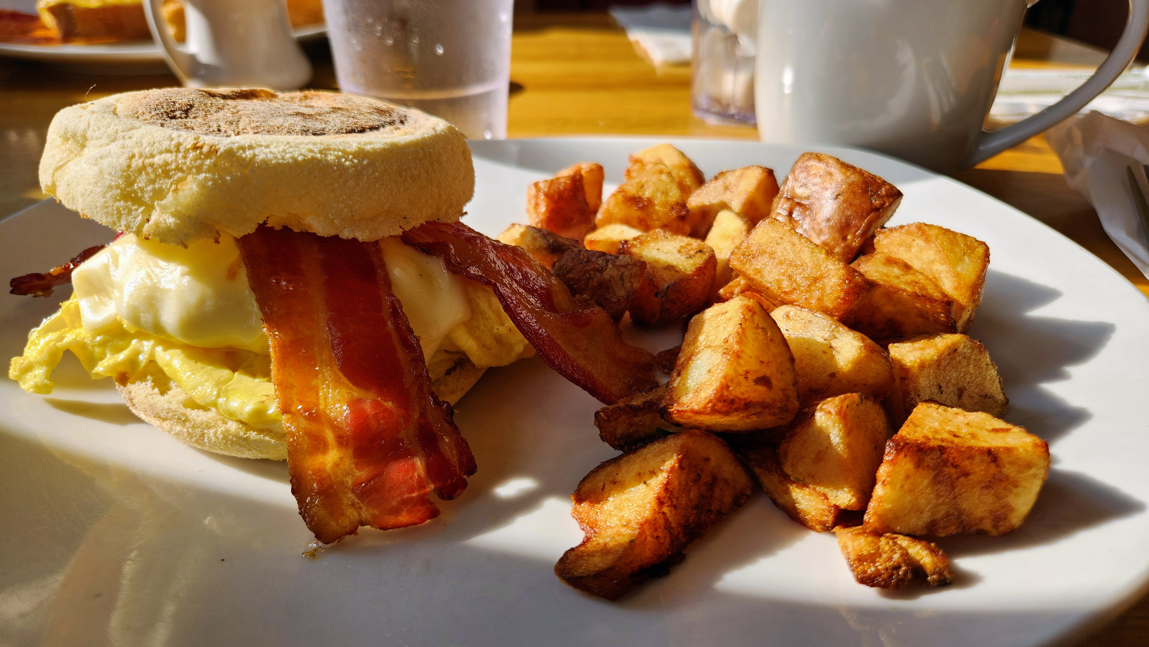 A breakfast sandwich and fried potatoes