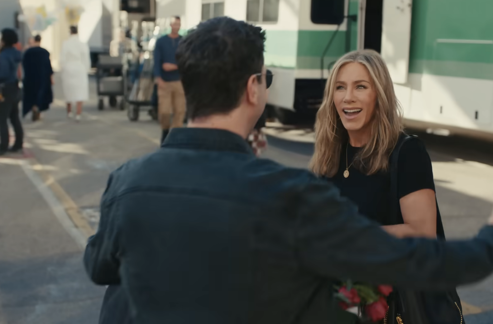 Jennifer smiling but clearly not knowing who David is in a scene from the? Uber Eats commercial