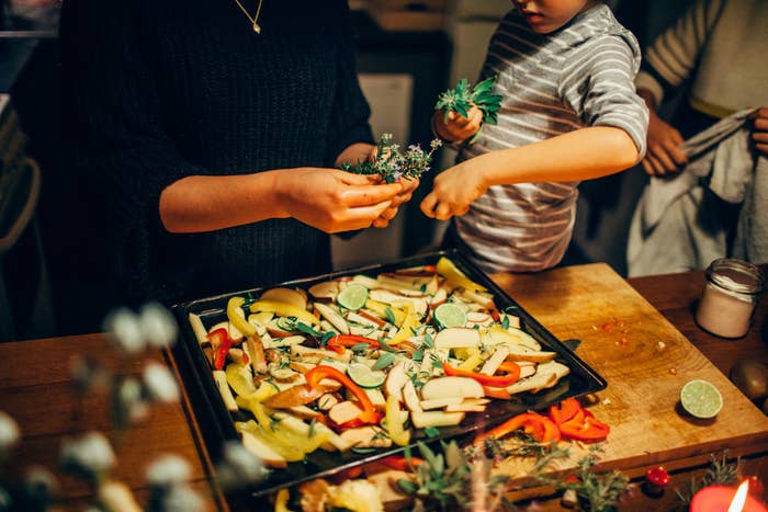 A woman and young boy cooking vegetables together