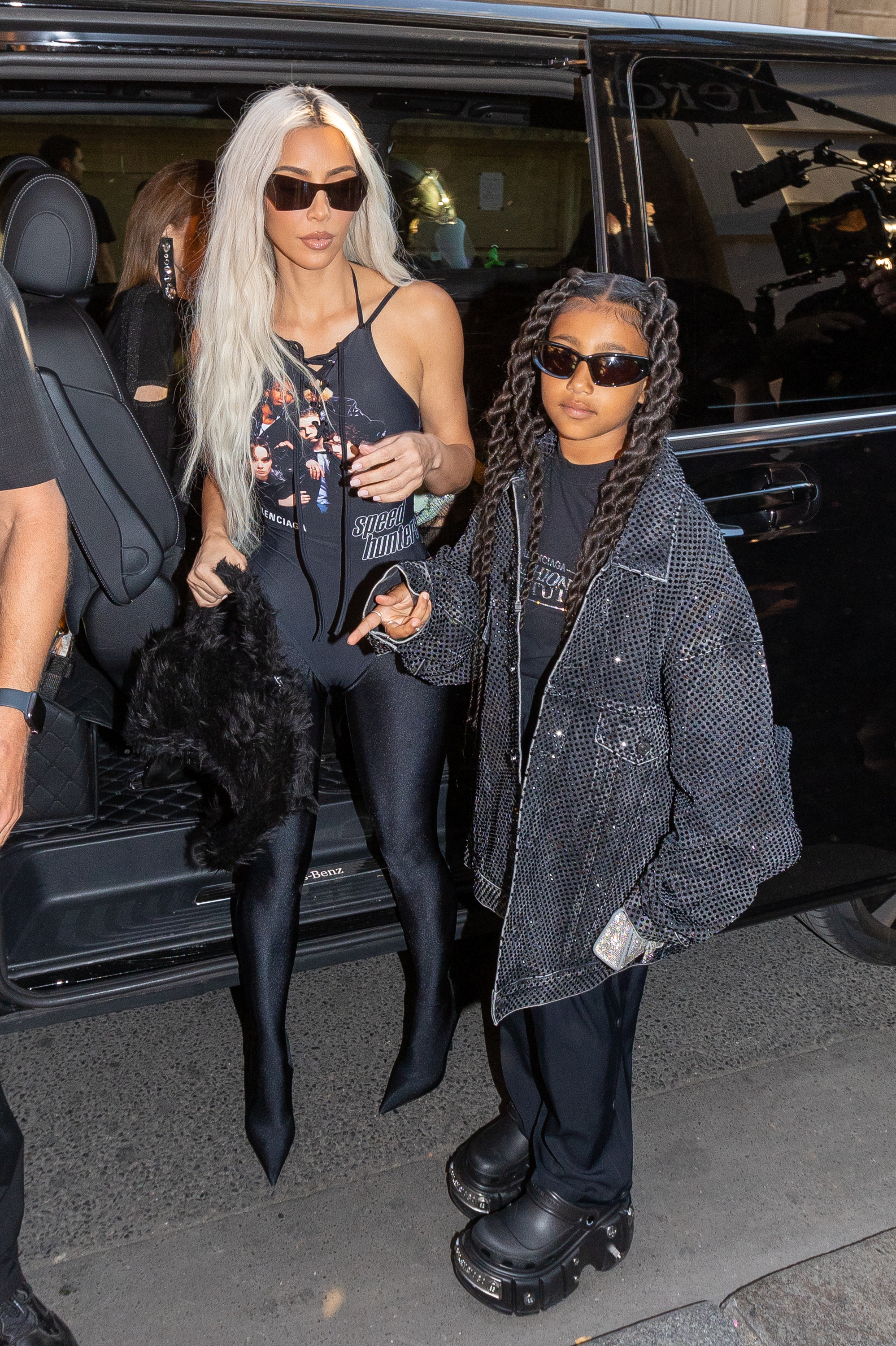 Close-up of North and Kim on the street in sunglasses by a car