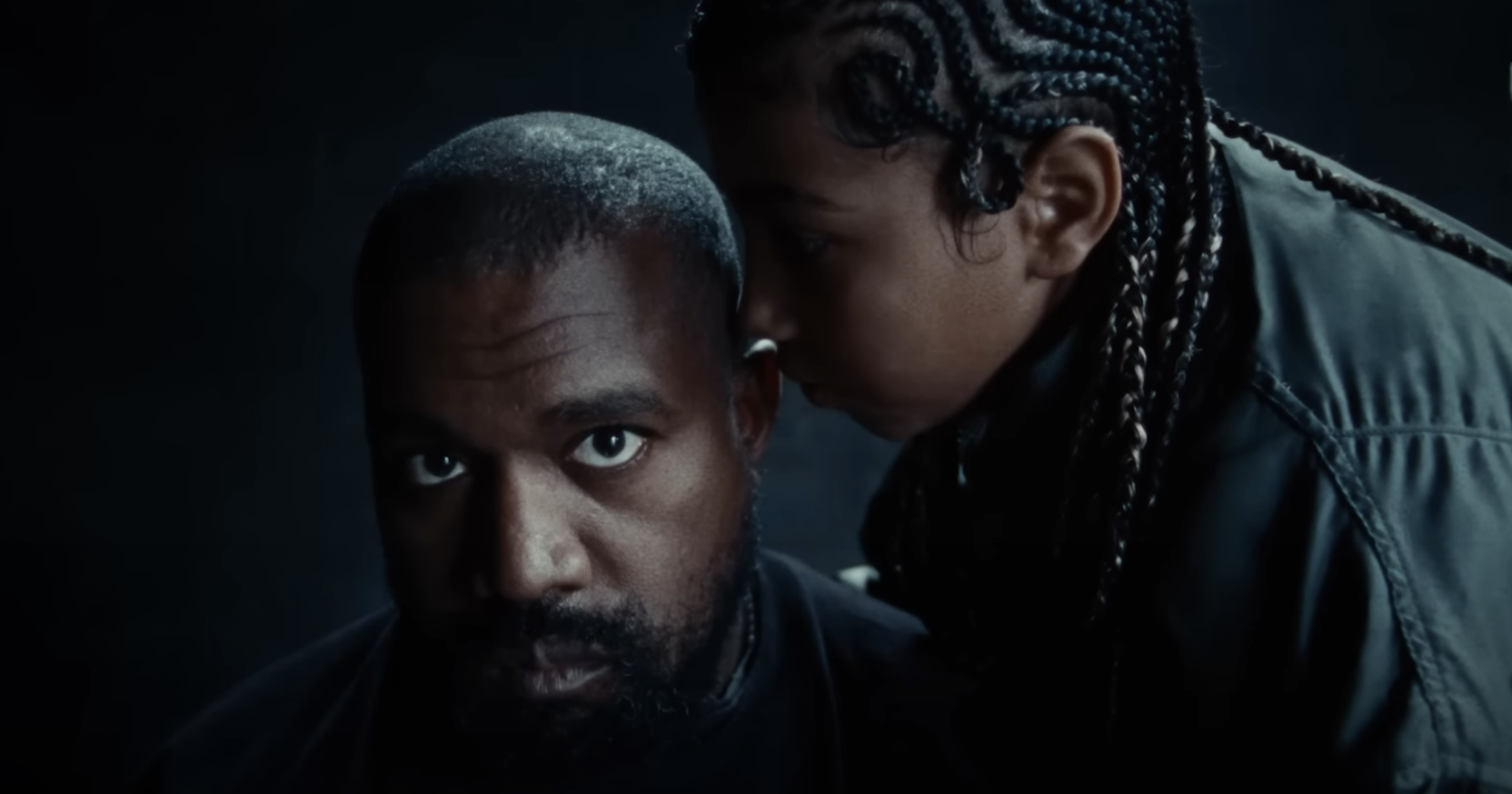 Close-up of Ye and North whispering in his ear