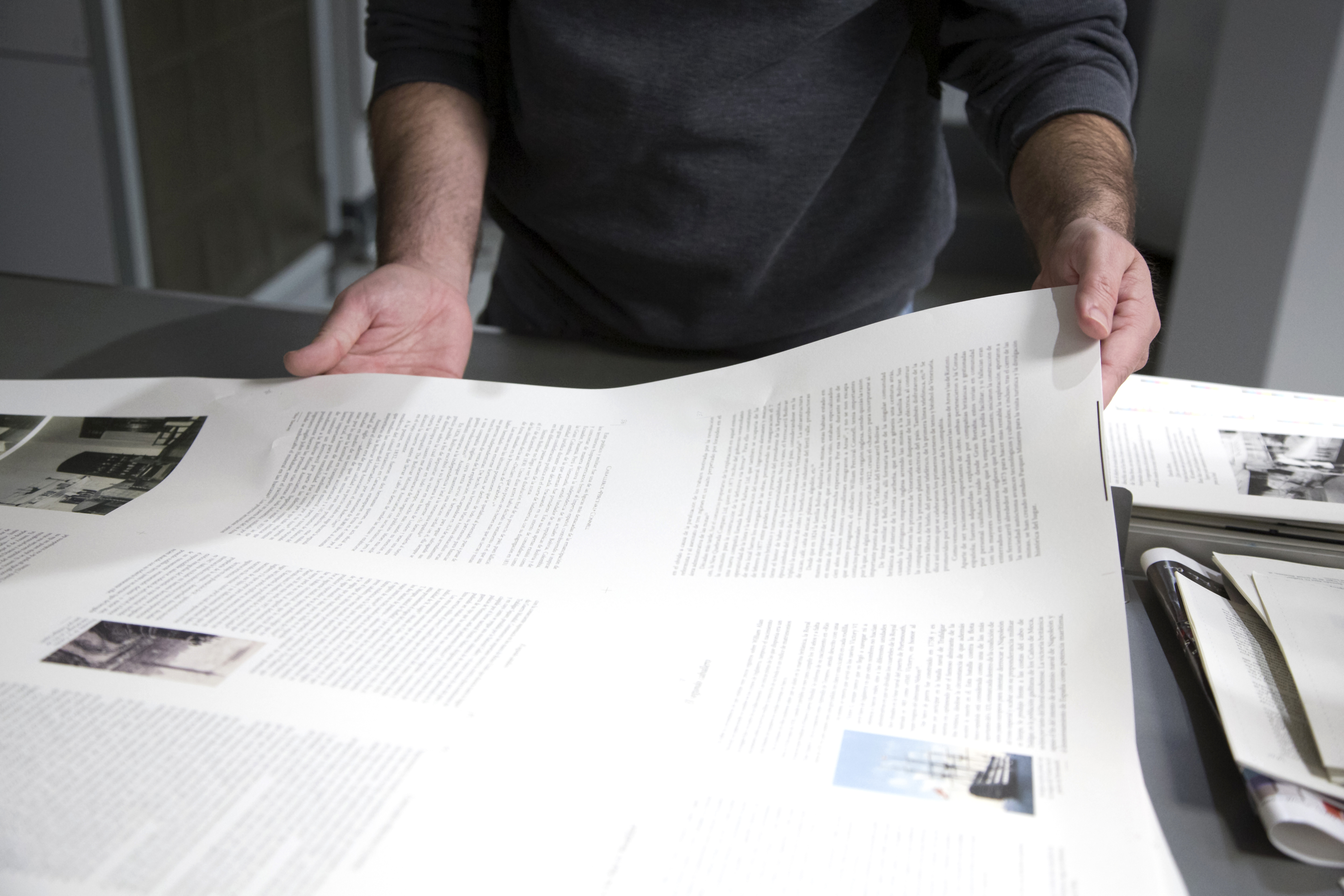 man holding a large print out of a book