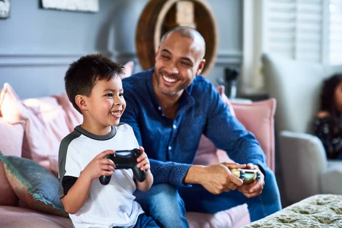 A father and son smiling as they play video games