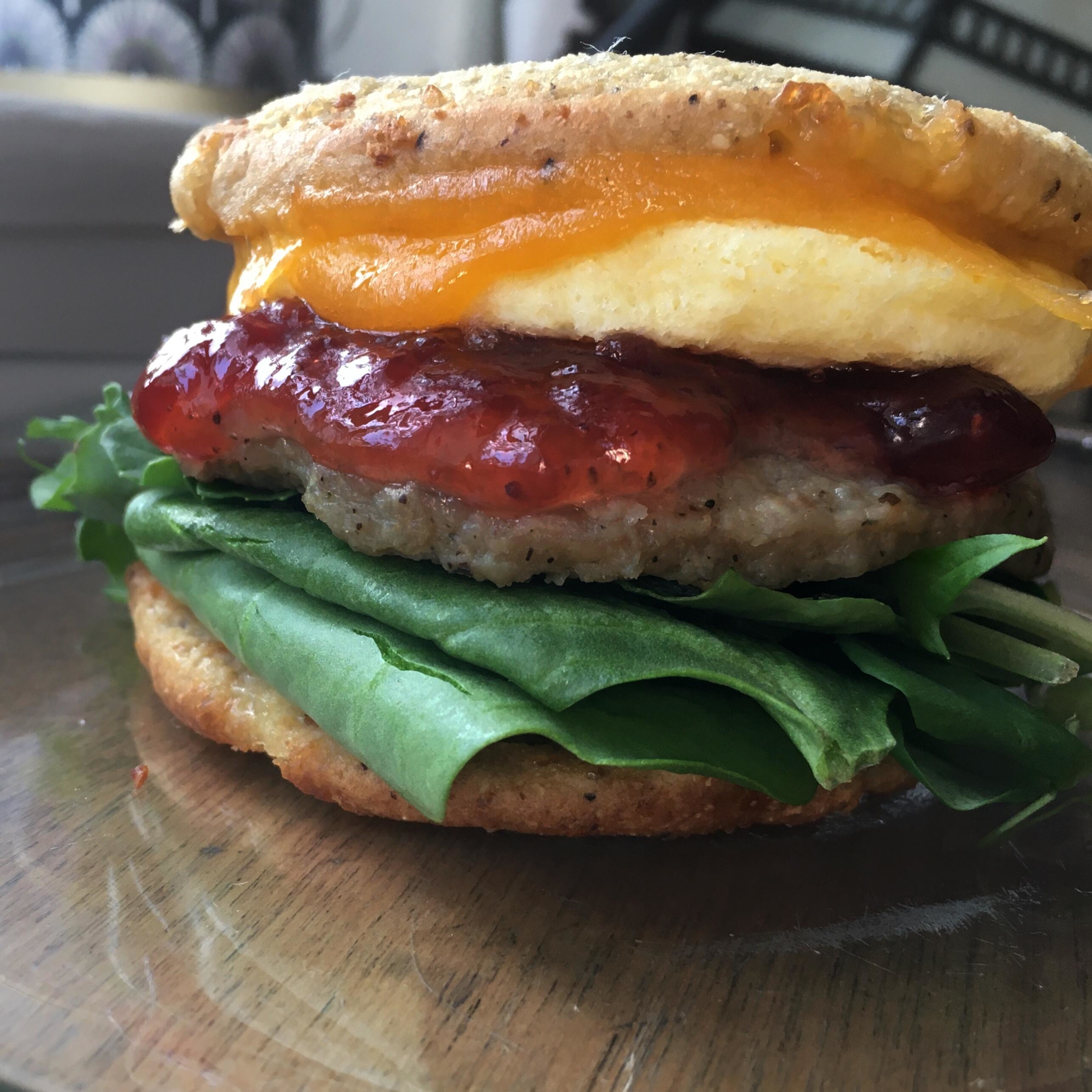 A sausage, egg, and cheese breakfast sandwich with jam