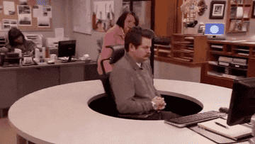 gif of Ron Swanson on Parks and Recreation spinning in an office chair to avoid someone