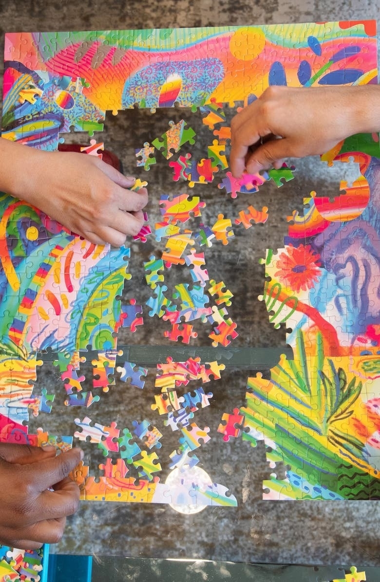 models putting together colorful jigsaw puzzle