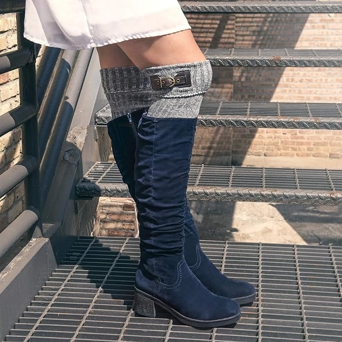 a model wearing the gray socks with navy blue knee boots
