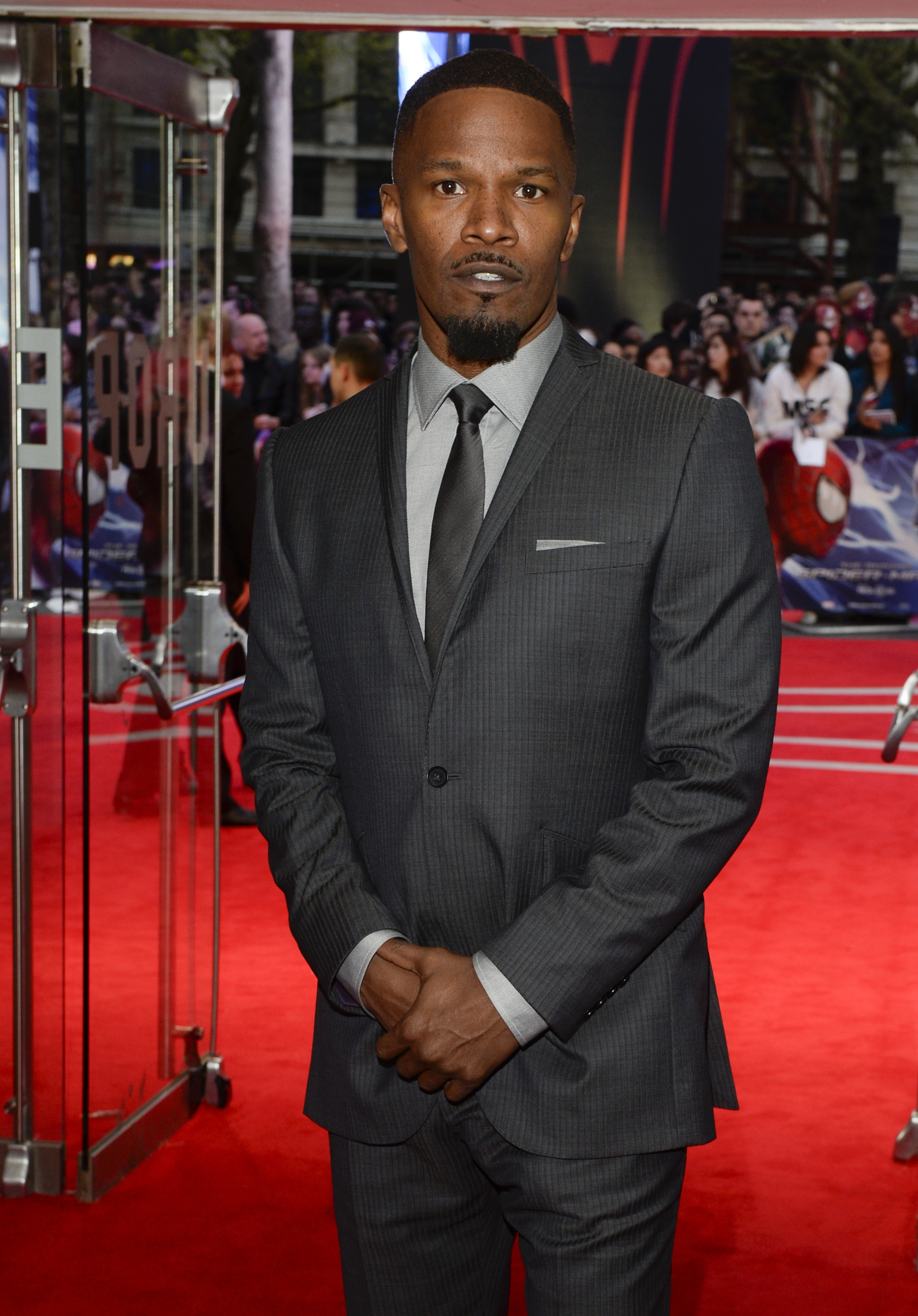 on the red carpet in a suit with a small beard and mustache