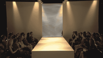 Audience seated beside a fashion show runway waiting for the event to start