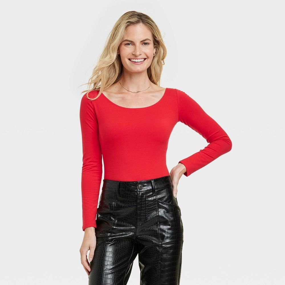 A person in a red scoopneck bodysuit