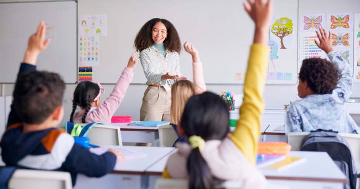 students raising their hands in class