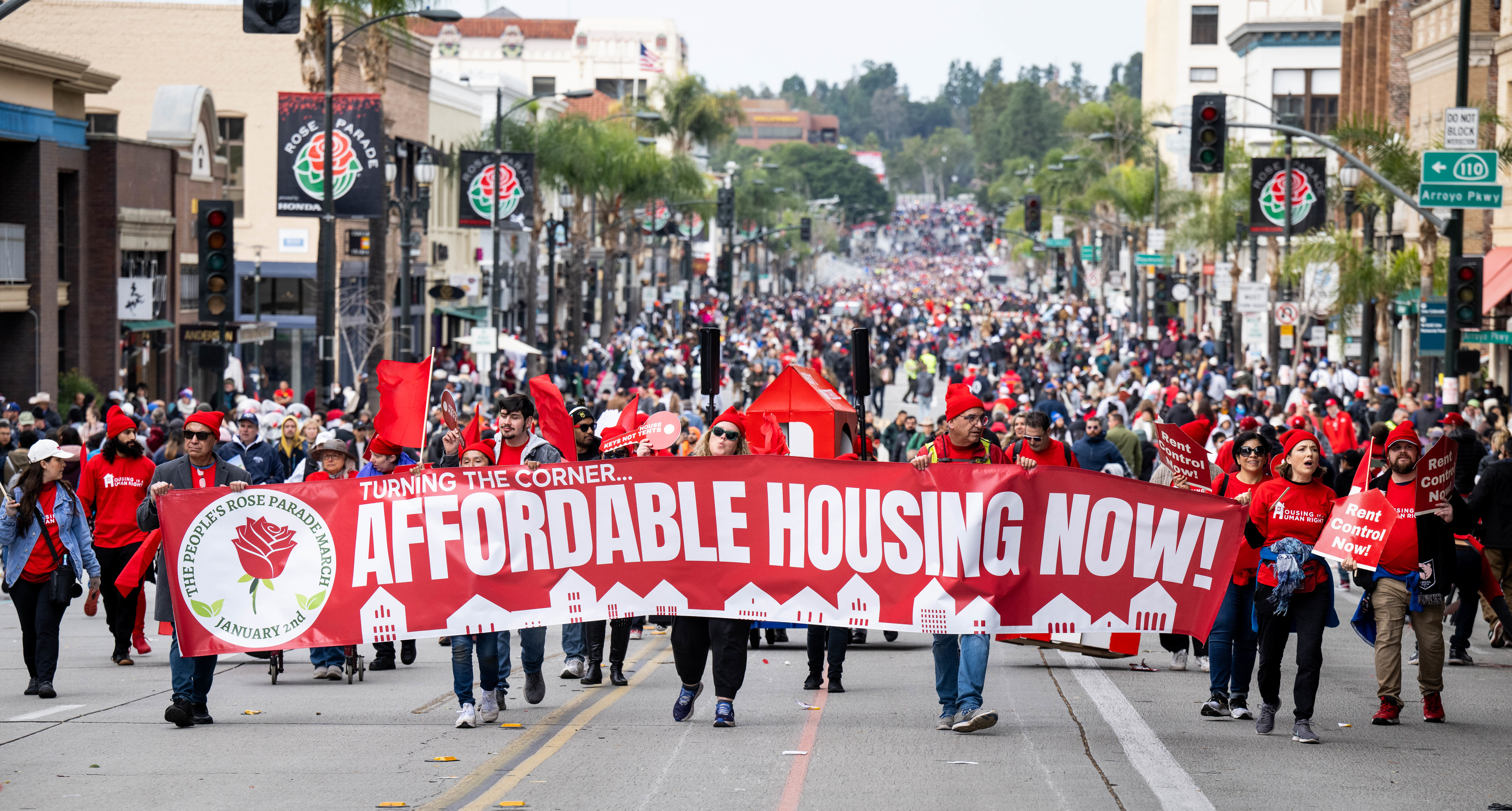 Protesters marching with a banner saying &quot;Affordable Housing Now!&quot;