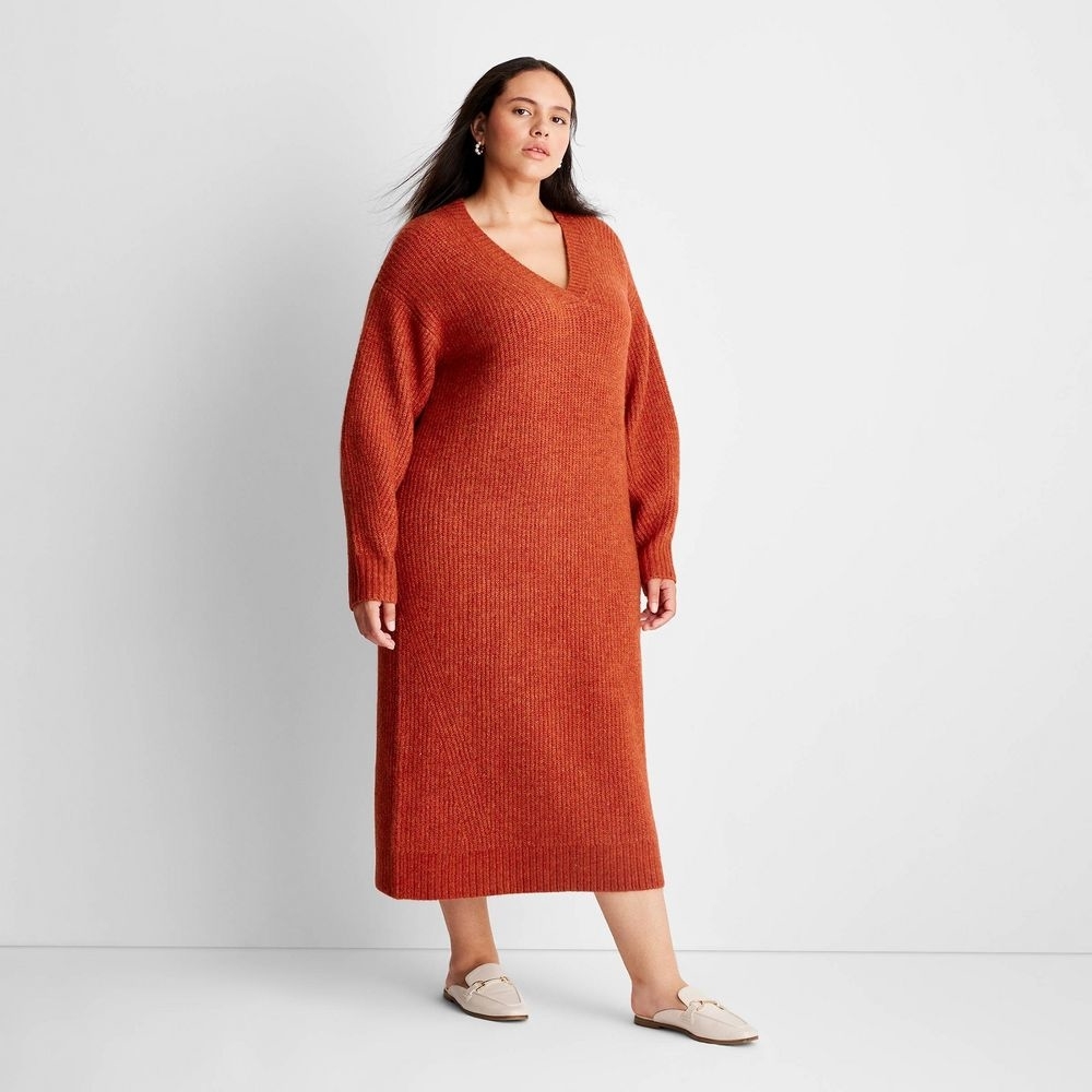 A person in a rust-colored long sweater dress