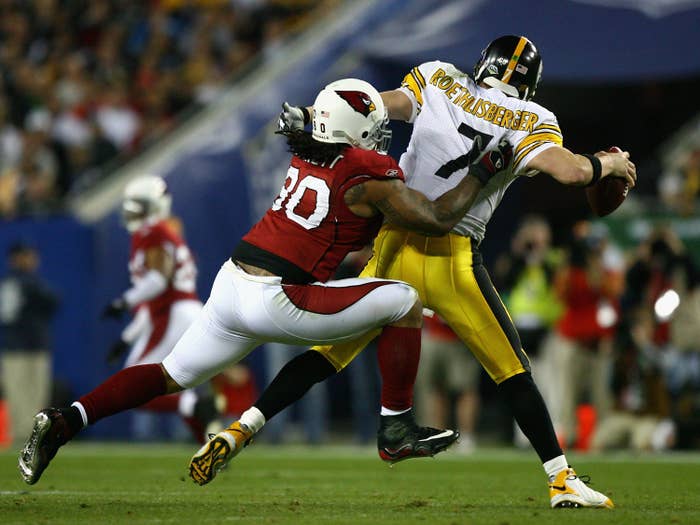 falcons player trying to tackle a steelers player who has the ball