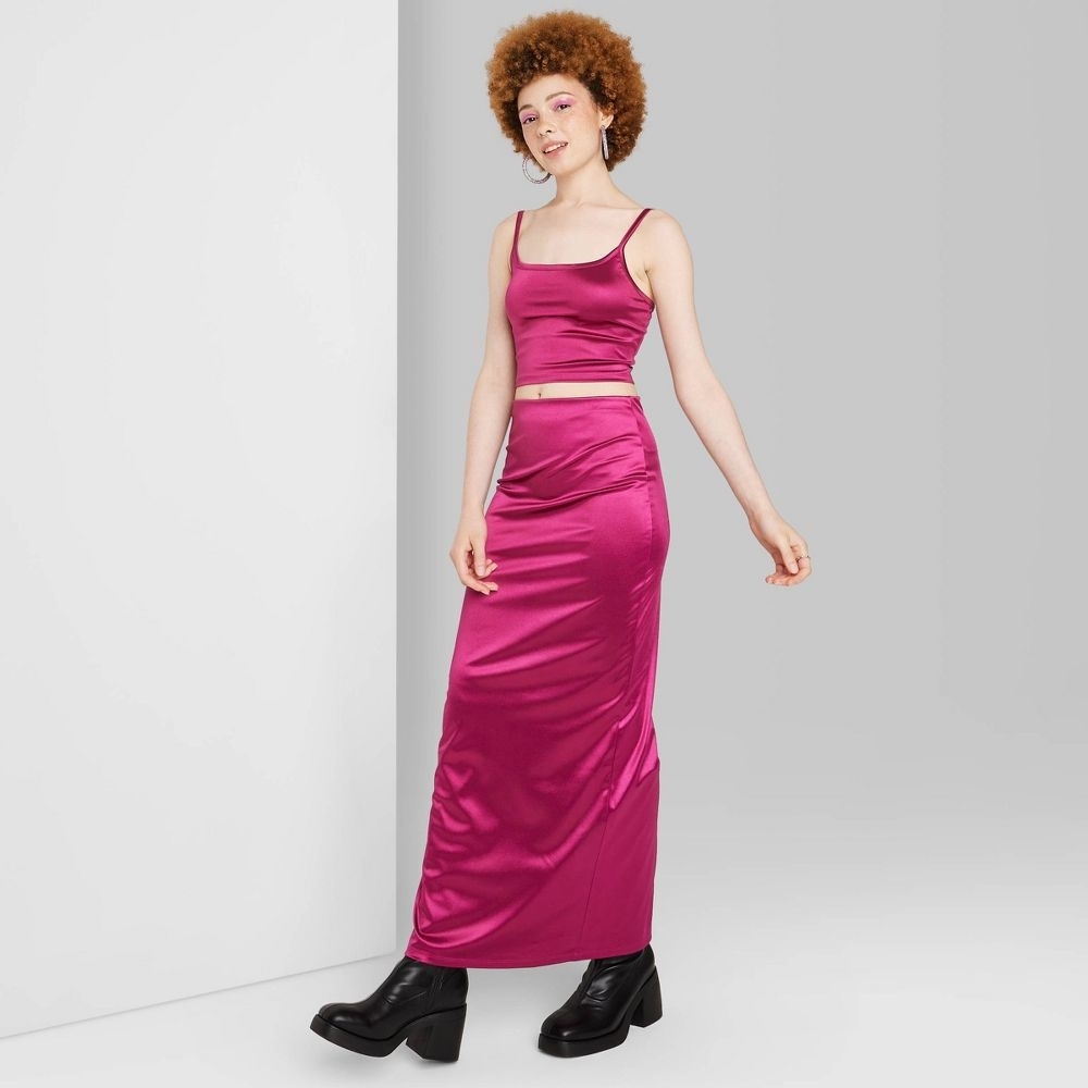a person in a pink shiny maxi skirt