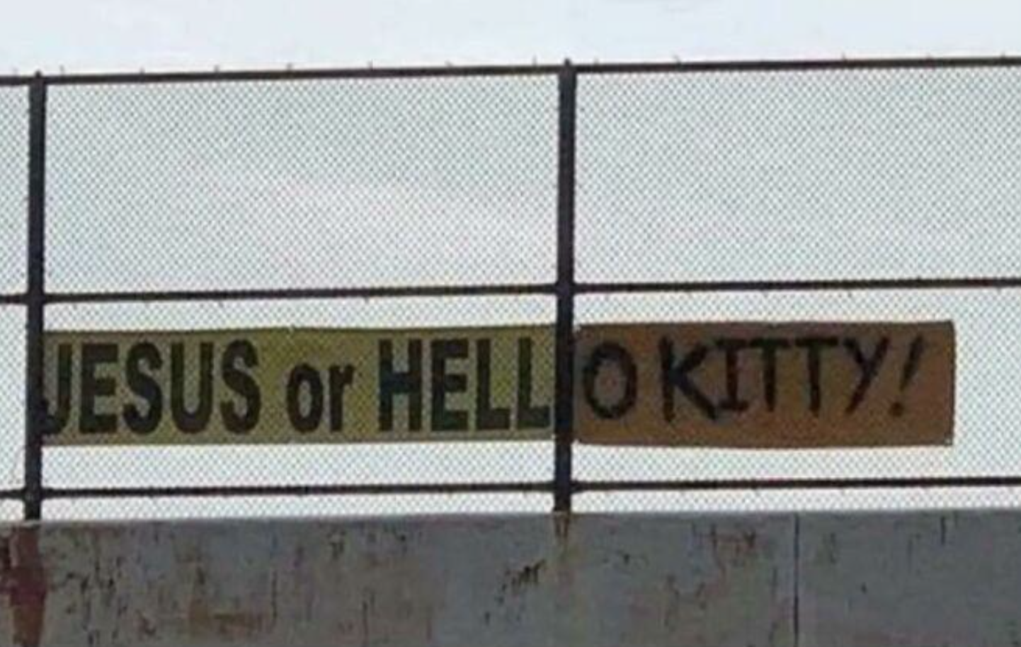 &quot;Jesus or Hello Kitty!&quot; sign on a fence