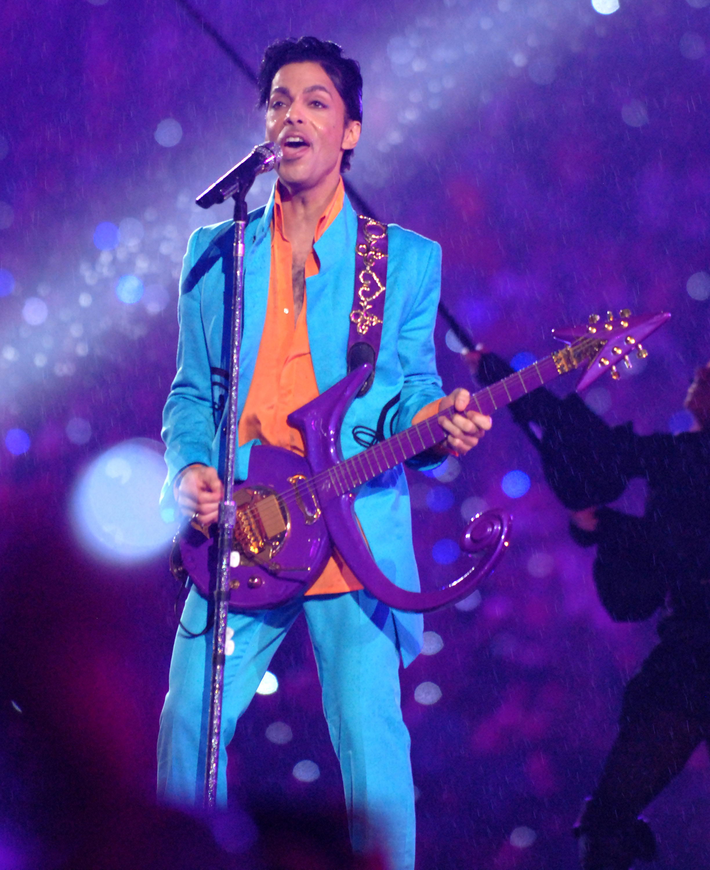 prince singing and playing guitar on stage