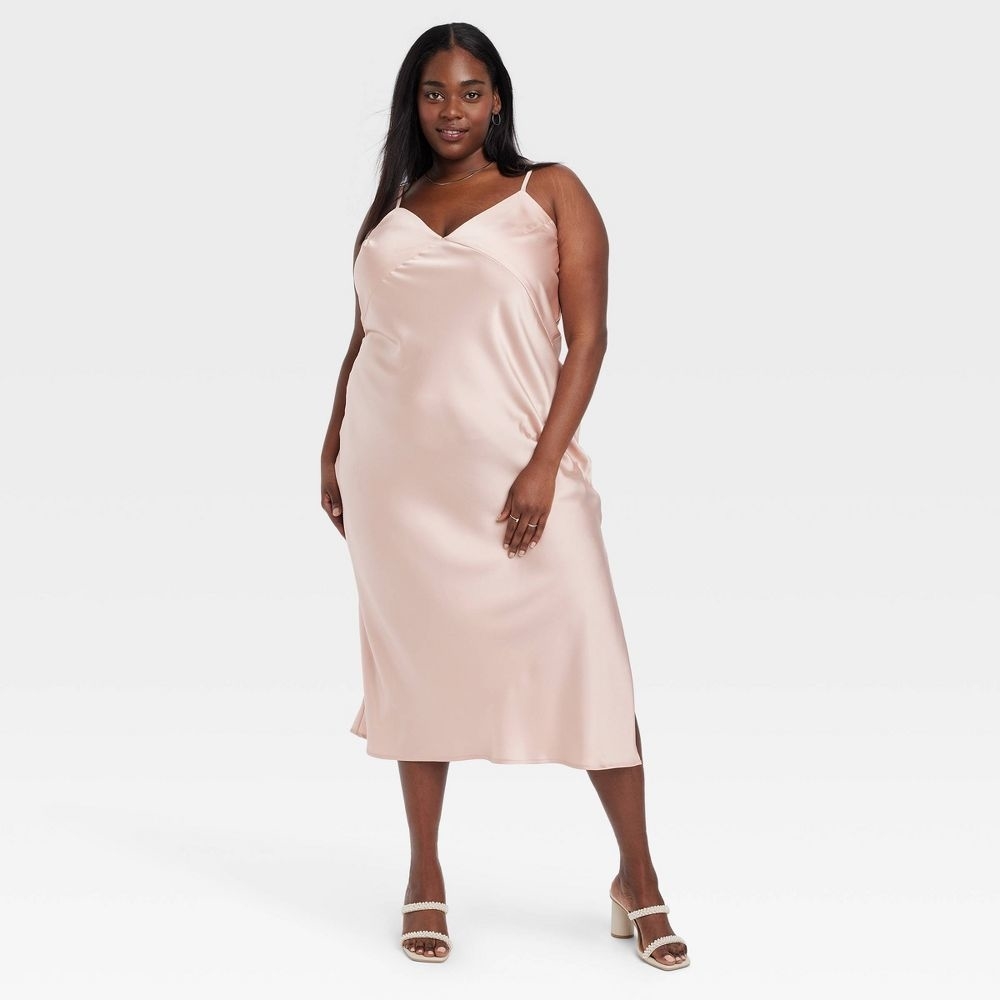 a person in a light pink slip dress