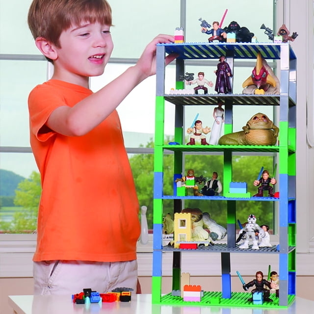 kid standing next to tower of base plates and blocks