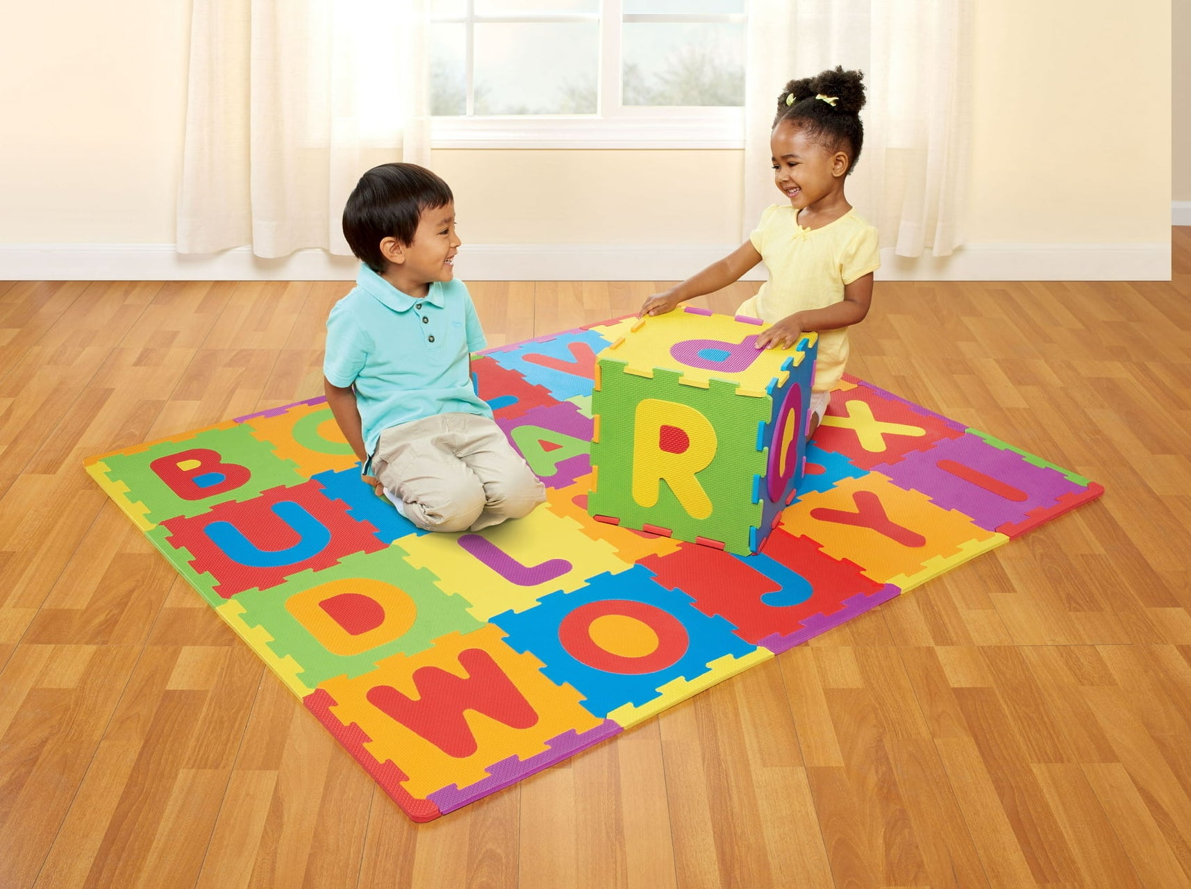 two kids sitting on a multicolor alphabet mat that can be assembled in various ways