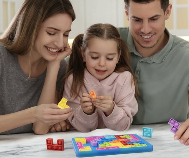 A family playing with pop it pieces while figuring out where the pieces fit into the puzzle