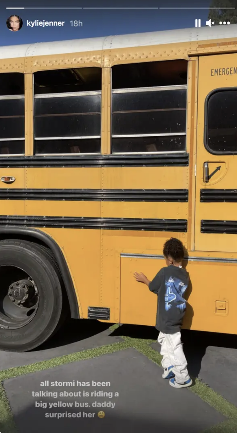 stormi touching a yellow school bus