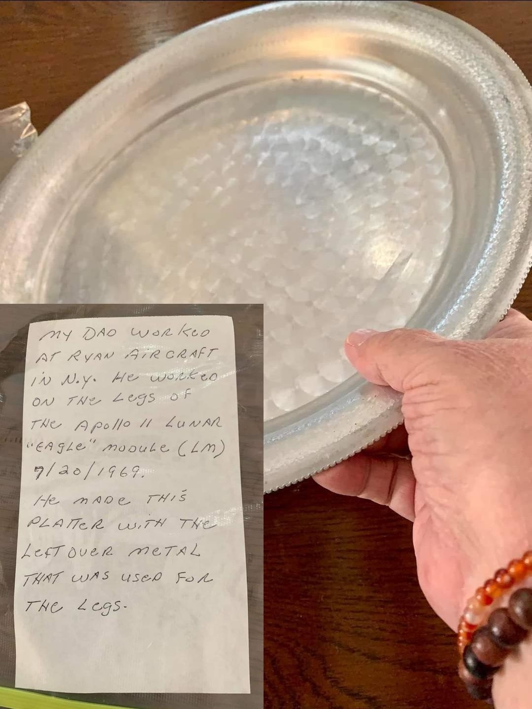 someone holding a metal platter with a note attached from the previous owner