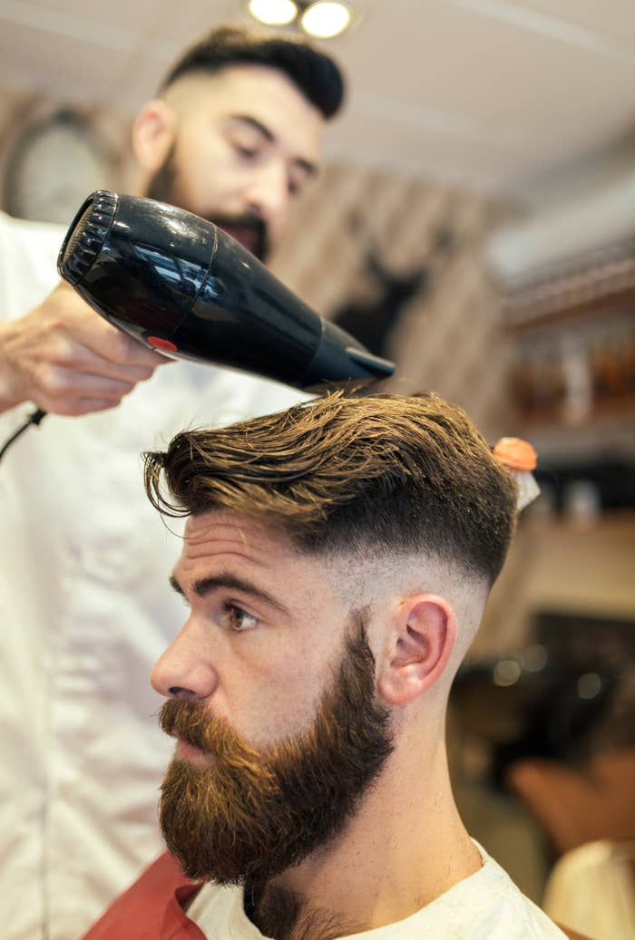 a barber doing a man&#x27;s hair
