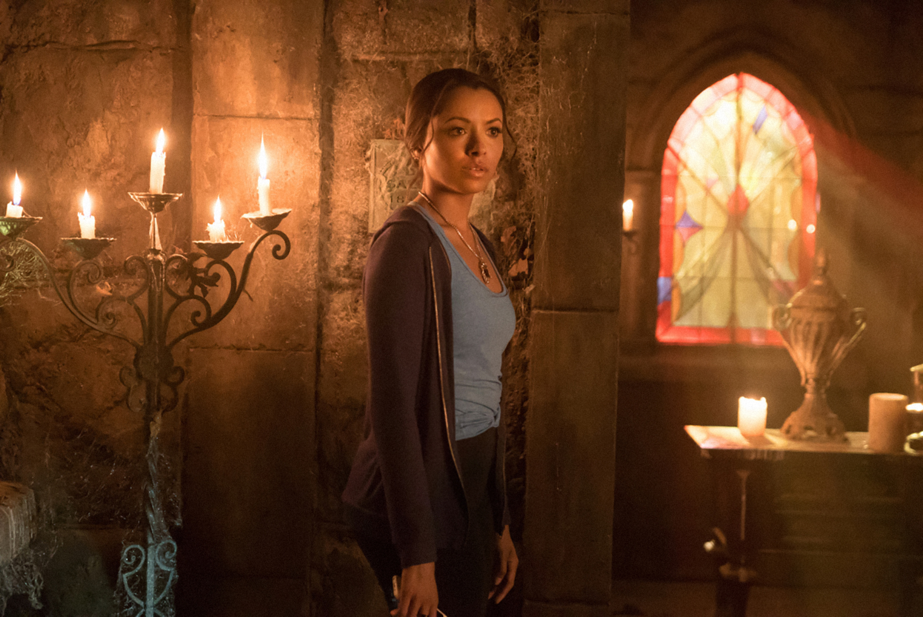 her character standing in a candlelit room