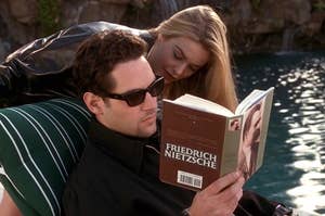 Josh from Clueless reading a book by the pool while Cher sneaks up behind him