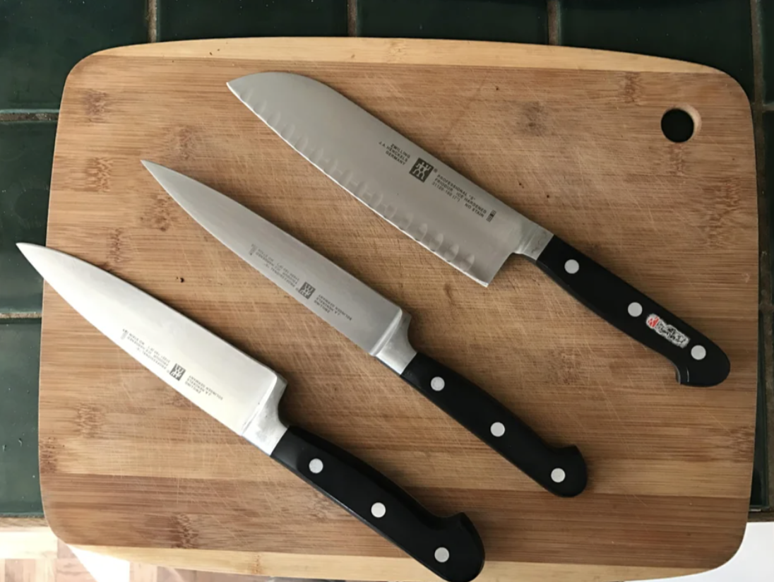 Three Henckels knives on a cutting board