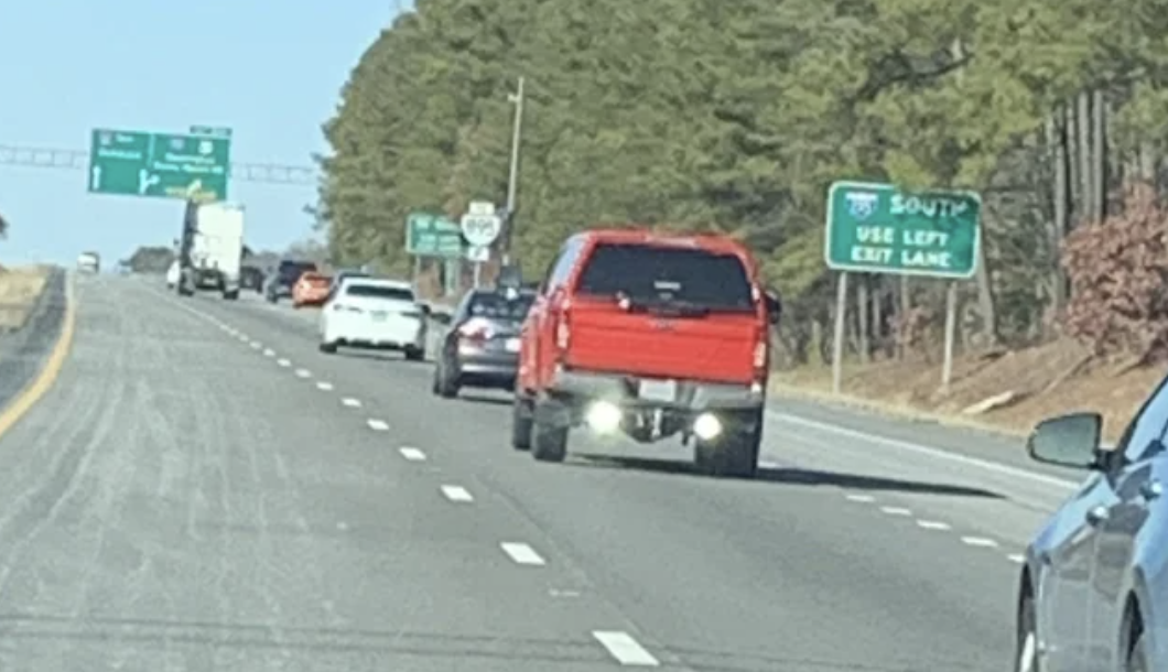 A car on the highway with two bright lights on the back of it