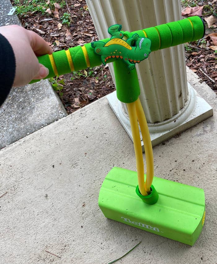 a reviewer photo of the green dinosaur pogo stick